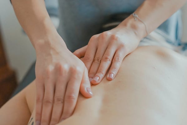 Therapist performing massage on client's leg during spa treatment session