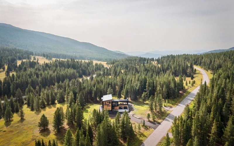 Aerial view of Bridger Canyon Passive Haus surrounded by forest and mountains